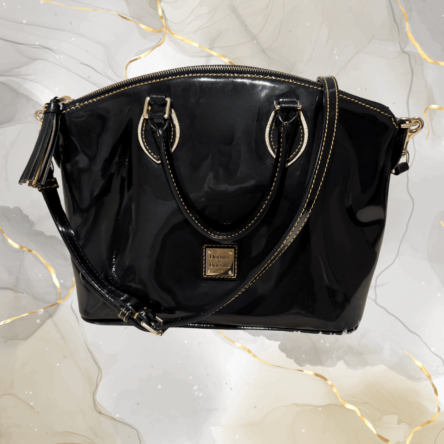 Pre-owned Dooney & Bourke black patent leather tassel satchel bag with gold-tone hardware.